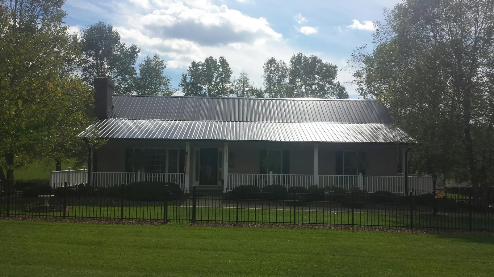 Gray metal roof on a brick ranch with a full width front porch — Gutter Guard Installation work by our crew in Gettysburg