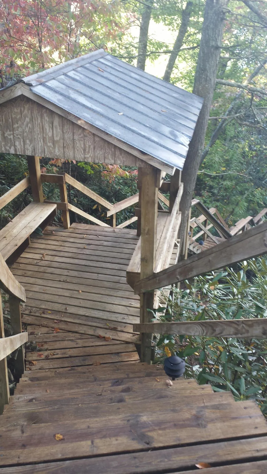 Metal roofed shelter over wooden steps on a wooded walkway — Skylight Repair & Installation work by our crew in Gettysburg